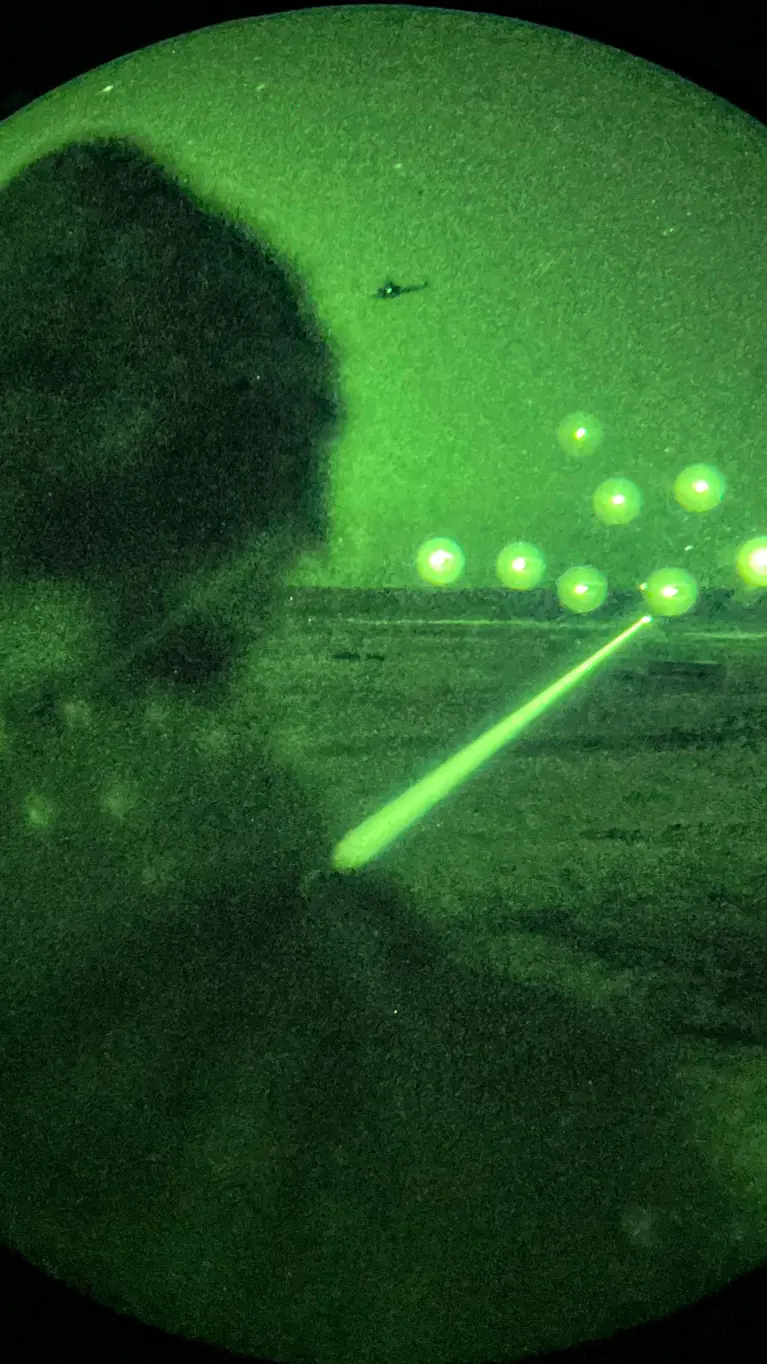 Een helikopter vuurt in het donker in Letland. 