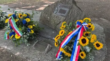 een gedenksteen met bloemen.