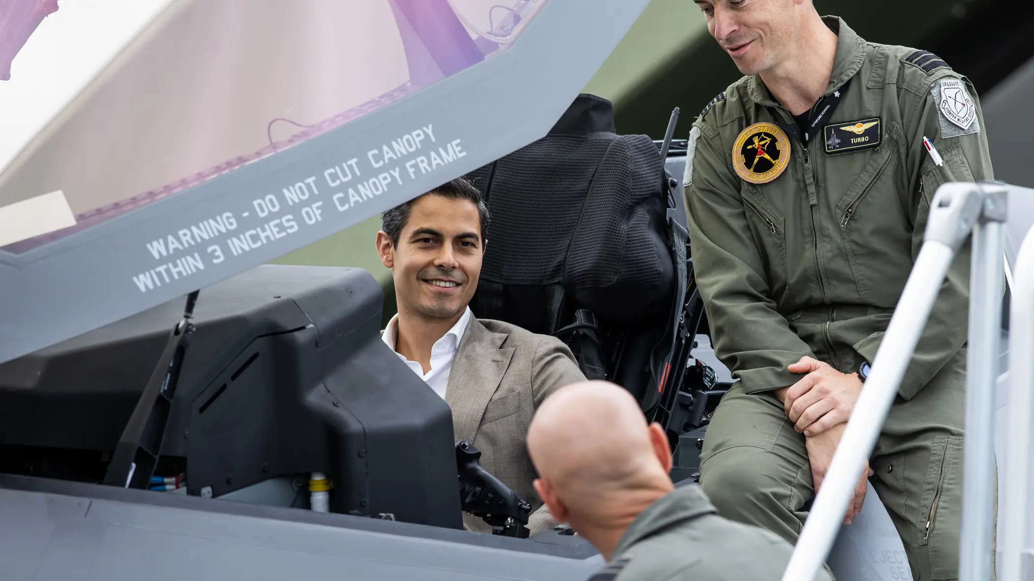 De premier zit in de cockpit van een gevechtsvliegtuig. 