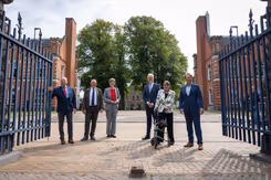 De ondertekenaars staan tussen de poorten van de kazerne. 