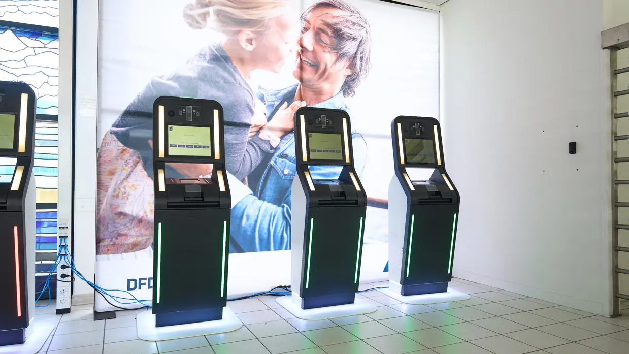 Een selfservice–kiosk die paspoort, het gelaat en 4 vingers van de rechterhand scant.