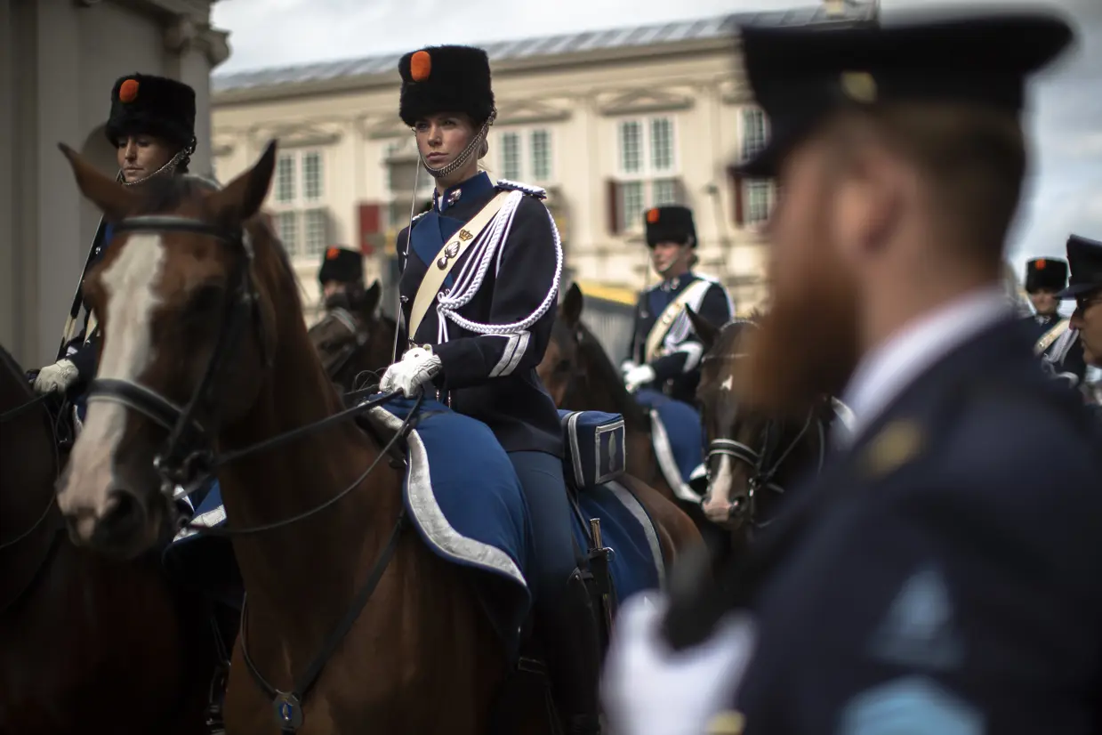 Een vrouwelijke marechaussee in ceremonieel tenue te paard.