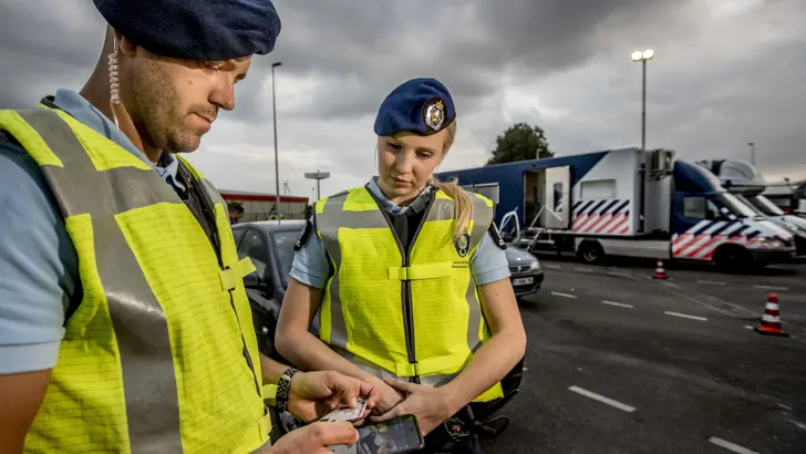 2 marechaussees checken een rijbewijs.