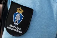 Logo van de marechaussee op de arm van een militair in uniform. 