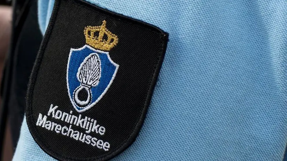 Logo van de marechaussee op de arm van een militair in uniform. 