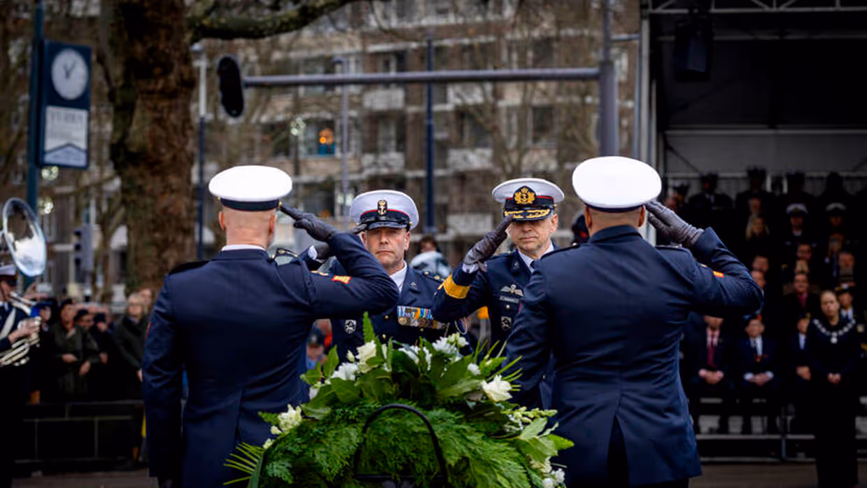 Militairen salueren bij herdenking.