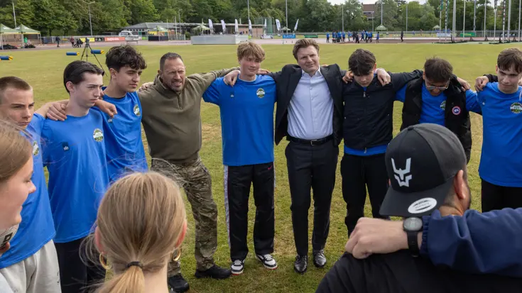Mensen in een kring, onder wie de minister.