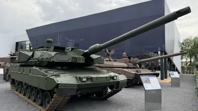  Een overzichtsshot van de Eurosatory met allerlei voertuigen op de voorgrond en de 2A8.