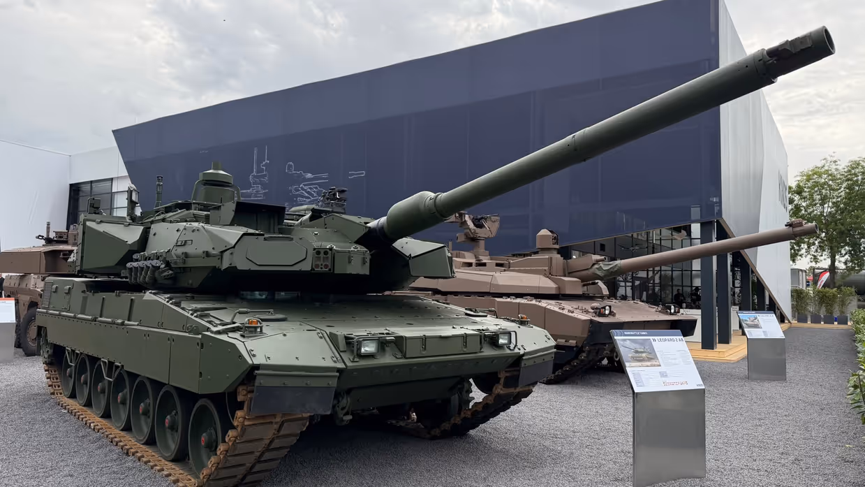  Een overzichtsshot van de Eurosatory met allerlei voertuigen op de voorgrond en de 2A8.