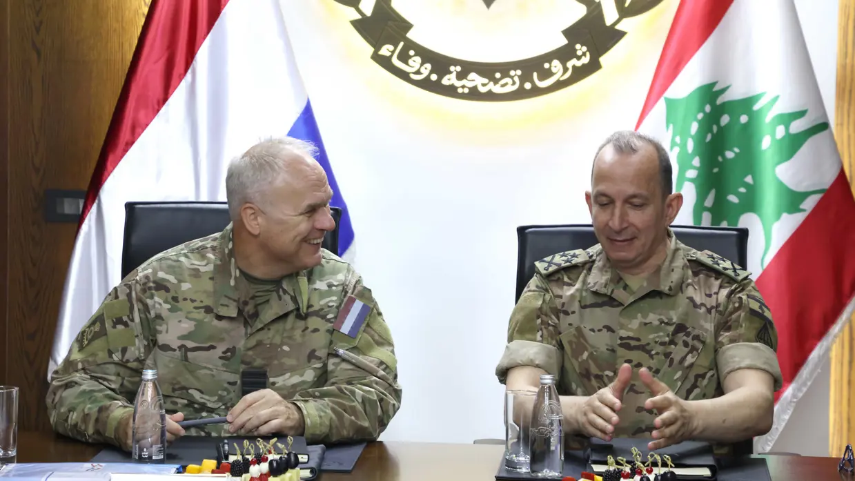 Twee hoge militairen zitten aan vergadertafel met achter hen de Nederlandse en Libanese vlag.