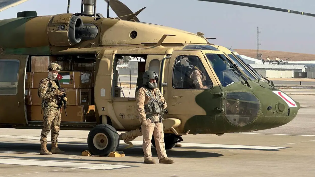 Helikopter met hulpgoederen wordt bewaakt door militairen.