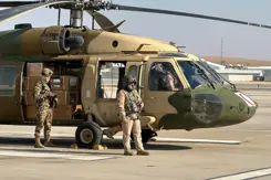 Helikopter staat aan de grond met 2 militairen erbij.