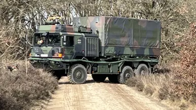  Links: Een militair voertuig probeert te keren, rechts: een militair voertuig rijdt door de bossen.