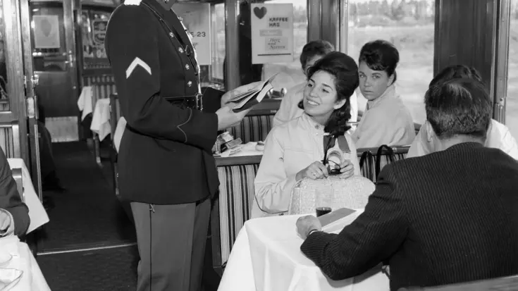 Historische foto: een marechaussee controleert papieren in een trein.