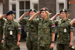 Militairen salueren, onder hen de koningin.