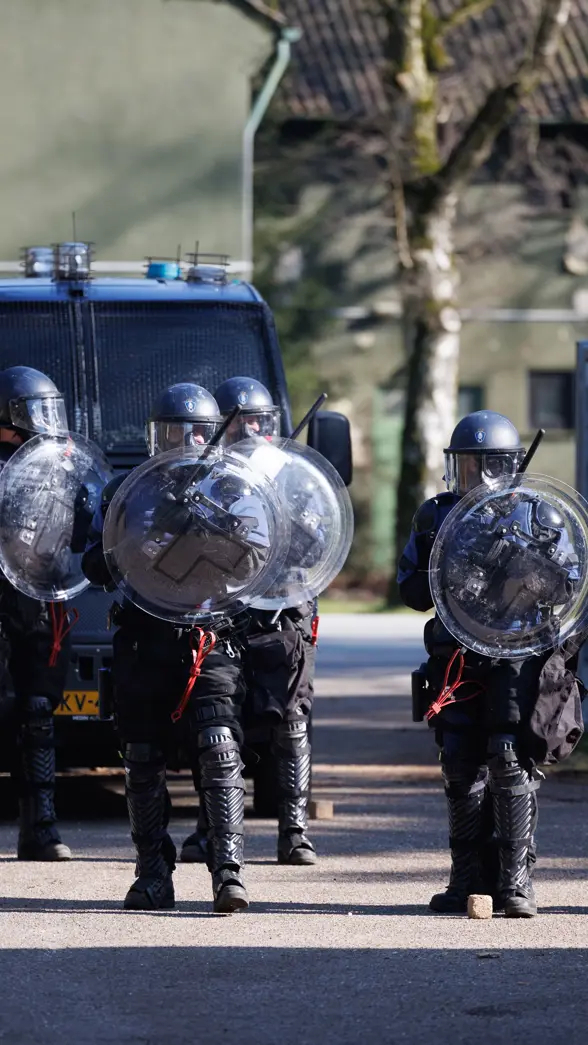 Marechaussees van de ME op linie met schilden.
