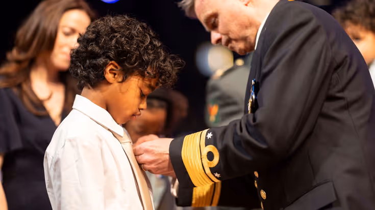 Kind krijgt medaille opgespeld