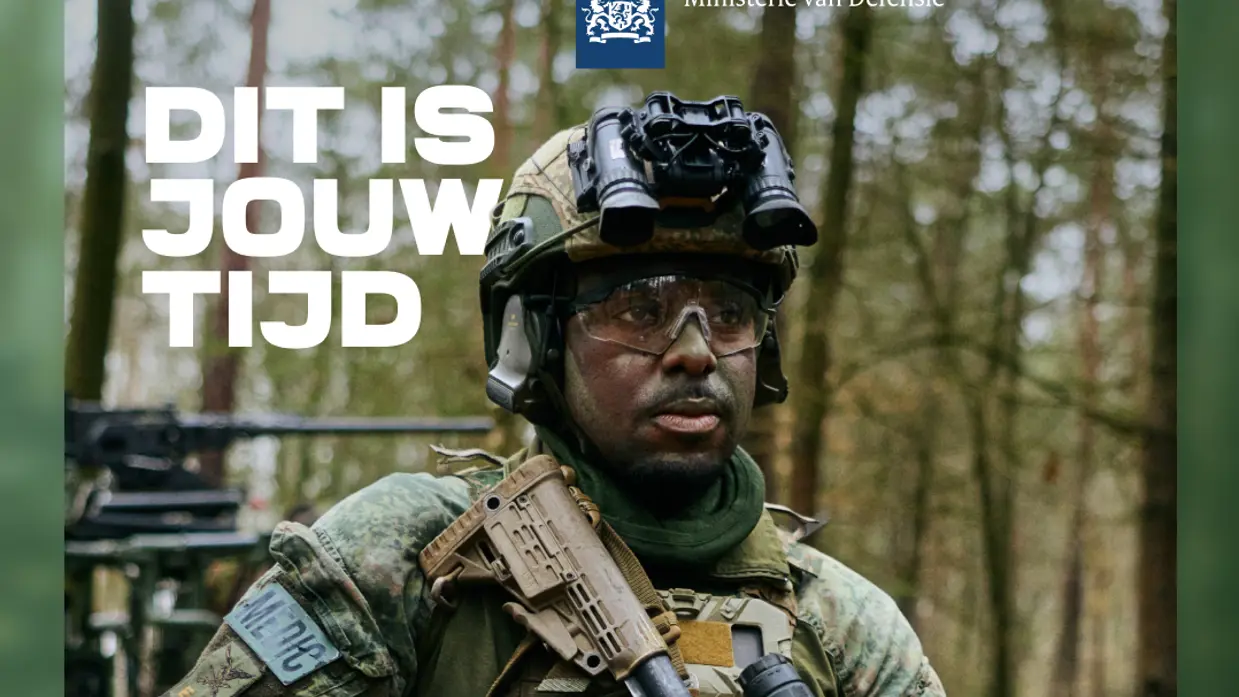 Een man in militaire kleding kijkt langs de camera.