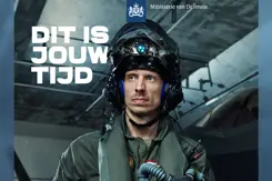 Een man in vliegerpak kijkt weg van de camera.
