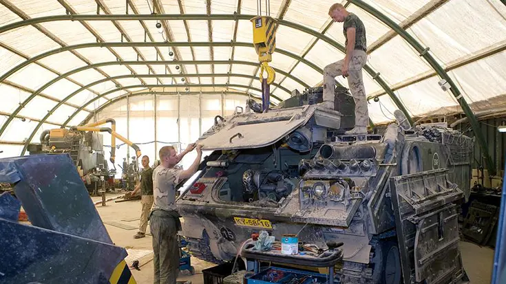 Militairen van 43 herstelcompagnie in stoffige hersteltent in Uruzgan.
