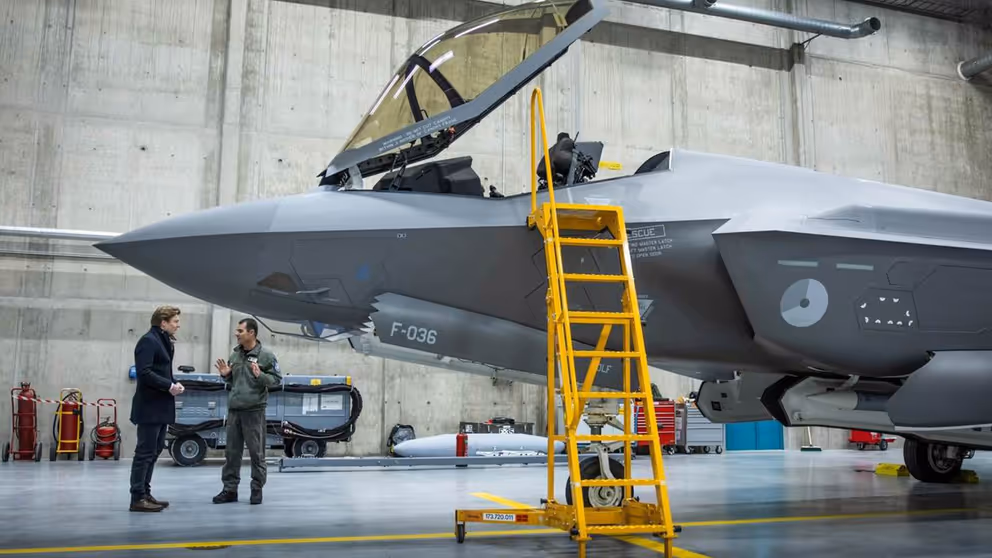 F-35 gevechtsvliegtuig staat in hangar met de cockpit open en een gele trap tegen het toestel.