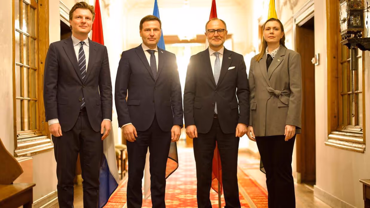 Drie mannen en een vrouw staan naast elkaar in formele kleding. Het zijn de Nederlandse minister van Defensie en drie Baltische collega's.