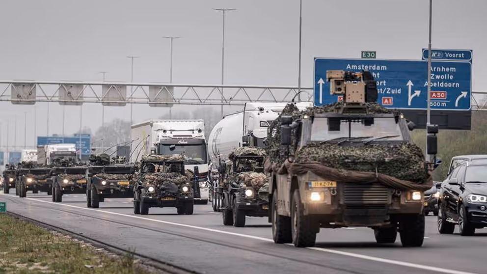 Militaire colonne rijdt over snelweg.