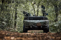 Gecamoufleerd militair voertuig rijdt door een bos
