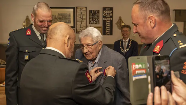 Een veteraan krijgt een medaille opgespeld.