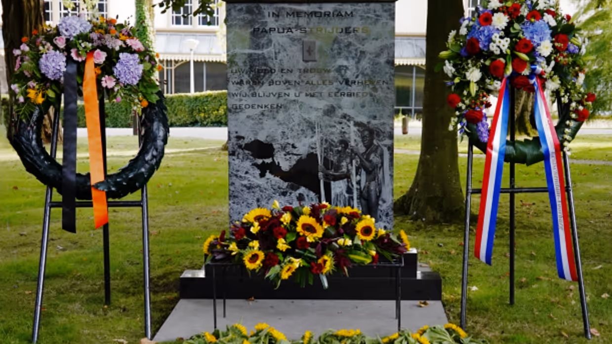 Het monument met een krans ervoor. 