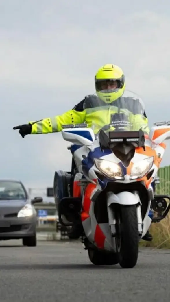 Motorrijder wijst een auto naar de zijkant van de weg