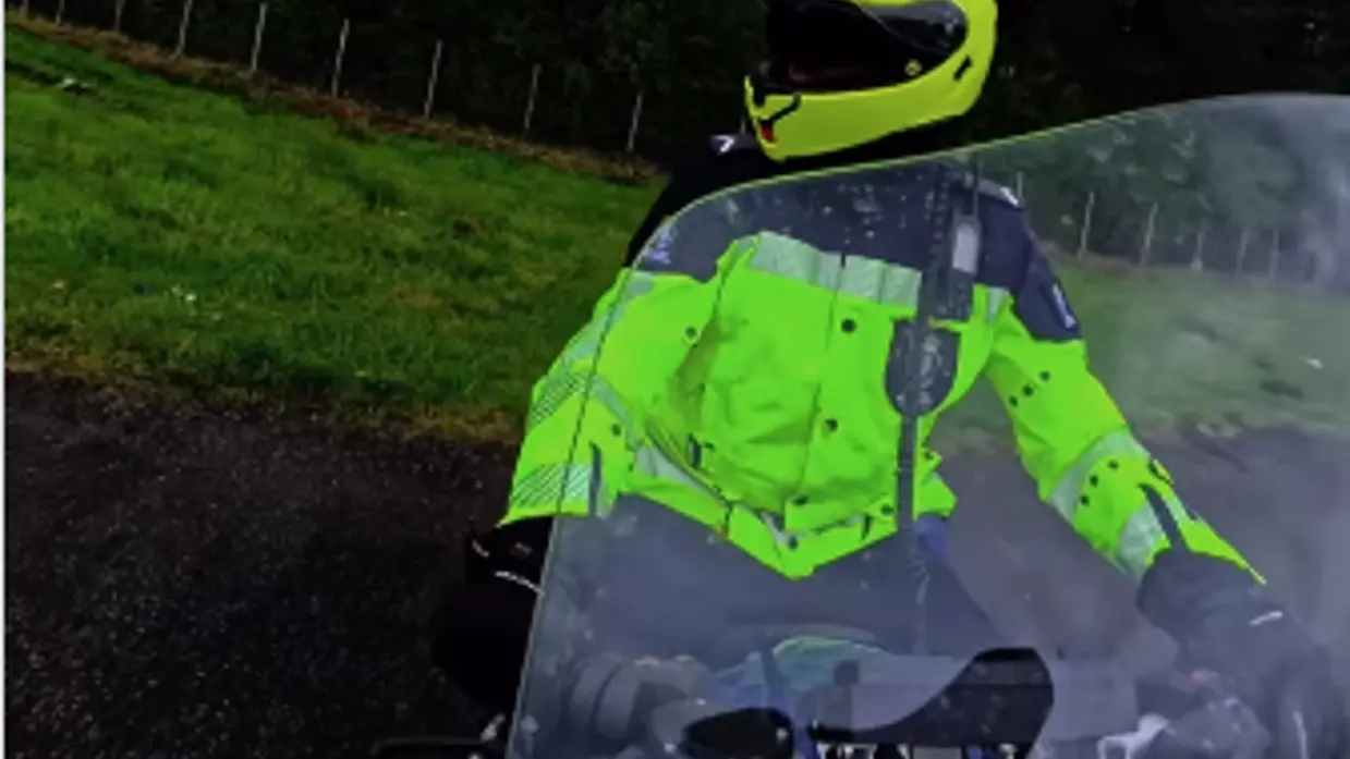 Een motorrijder van de KMar op de snelweg van voren gezien.