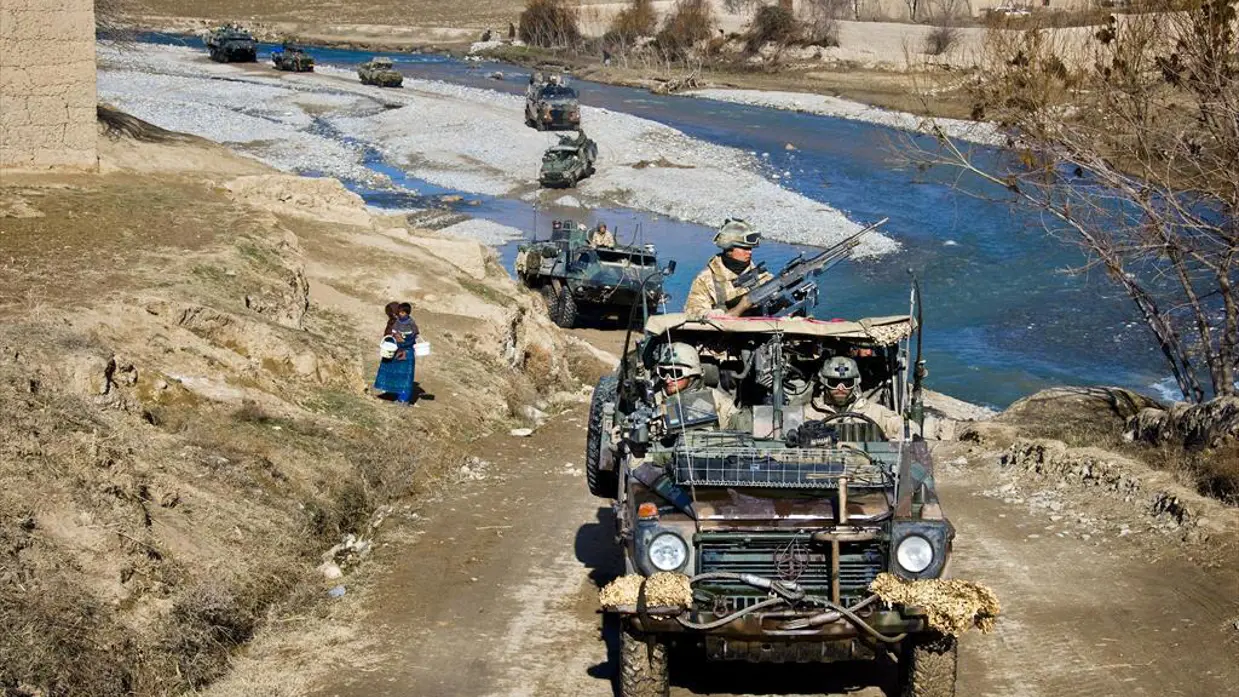 Een Nederlandse patrouille, onder andere bestaand uit Mercedes-Benz terreinwagens en Patria-pantserwagens, steekt een rivier over.