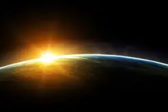 Ruimtefoto van bolling van de aarde met opkomende zon die over deel aarde schijnt.