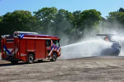 Een brandweerwagen blust.
