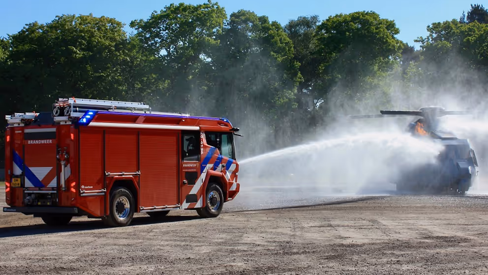 Een brandweerwagen blust.