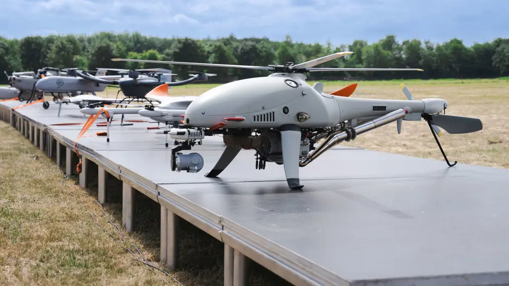 Tentoongestelde drones op platform in open veld.