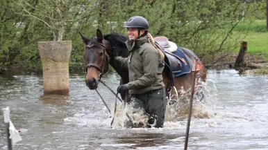 Een glimlachende vrouw met een helm op leidt met de teugels in de hand haar paard door het water (links) en (rechts) dezelfde vrouw springt met haar paard over een hindernis.