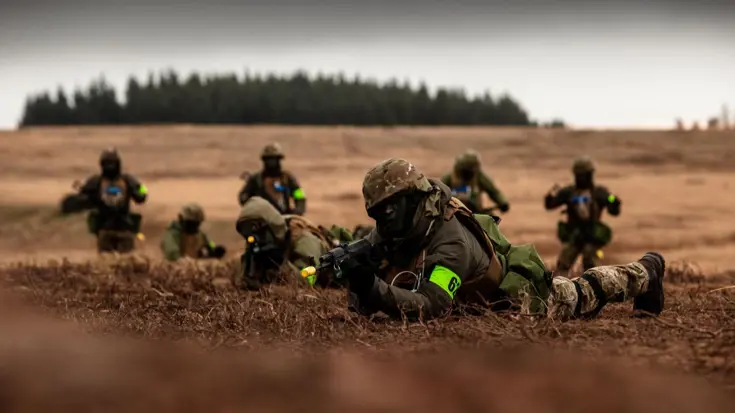 Bewapende militairen in het veld.