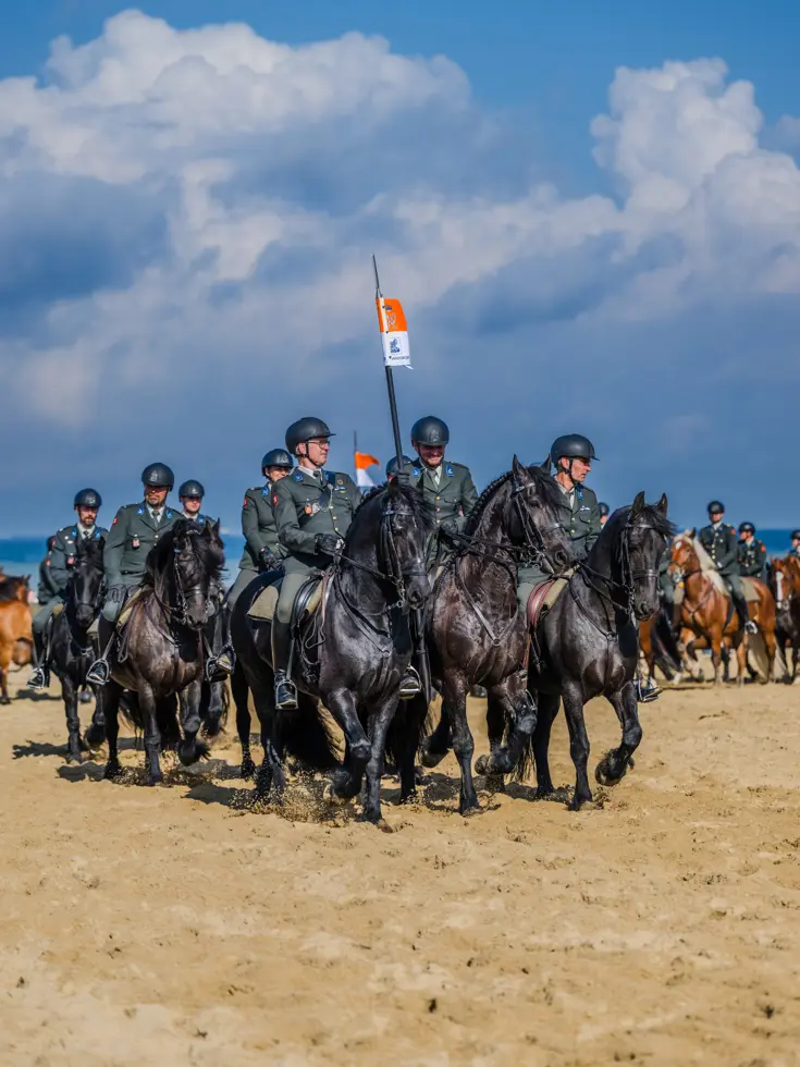 Militairen van de Cavalerie Ere Escorte te paard op het strand.