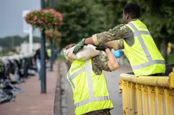 Militairen geven zandzakken door.