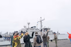 Op de kade zwaaien de thuisblijvers naar de bemanning op het schip.