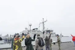 Op de kade zwaaien de thuisblijvers naar de bemanning op het schip.