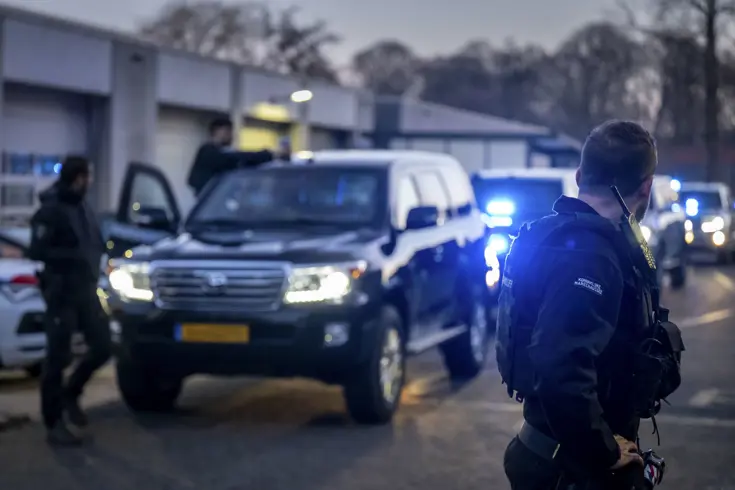 Voertuigen van de ME en politie met mannen met schilden ervoor.