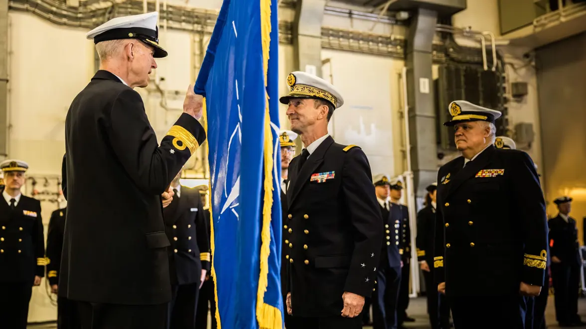 Ceremonie waarbij een militair een vlag overdraagt.