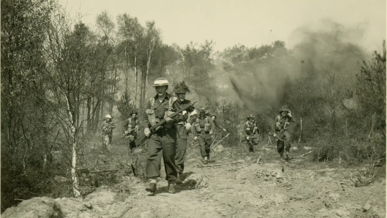 Militairen lopen over een veld.
