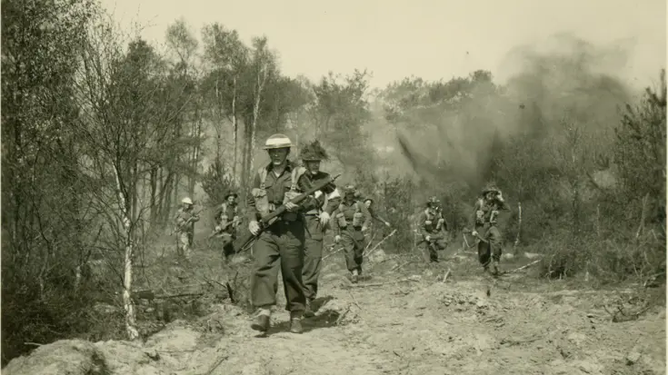 Militairen lopen over een veld.