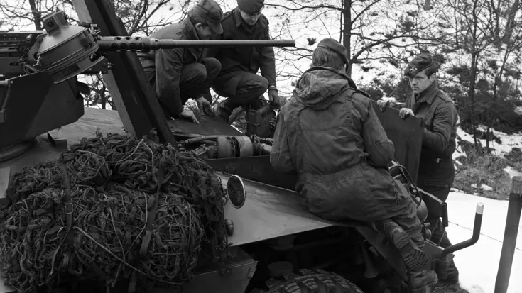 Militairen leunen op een jeep tijdens een oefening.