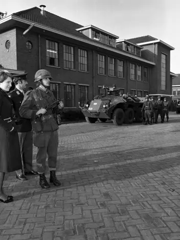 Prinses, militairen en een militair voertuig staan voor een gebouw op de Westenbergkazerne in Schalkhaar.
