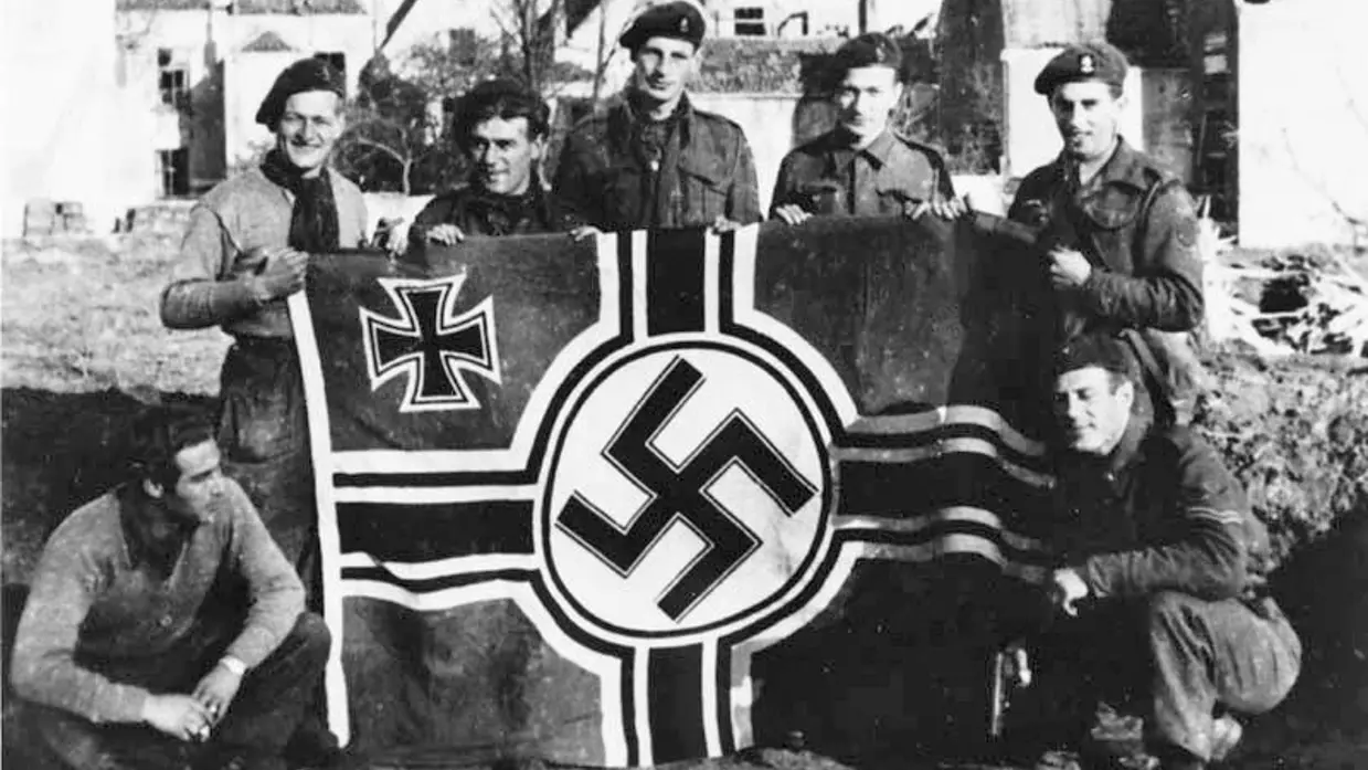 Militairen met een vlag met ijzeren kruis en hakenkruis.